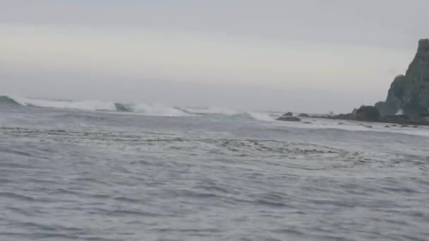 Visa från segling ship onstormy havets vågor kraschar till cliff island — Stockvideo