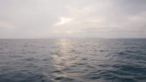 Sunlight przez chmury, odzwierciedlając w morze fale z łodzi żaglowych — Wideo stockowe
