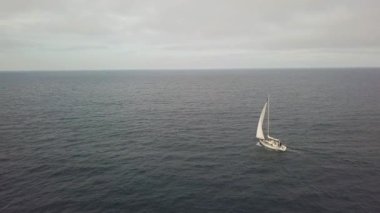 Beyaz yelken yat yelken mavi deniz ve bulutlu gökyüzü manzara dron görünümü