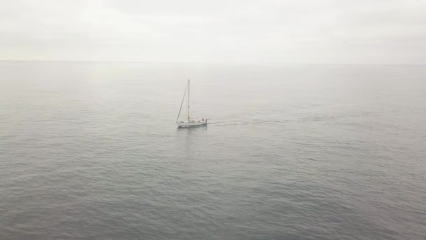 Zobrazit shora létající dron jachtu plachtění v moři a zamračená obloha na obzoru — Stock video