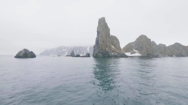 Скалистые скалы и горы со снежными вершинами в зимней морской воде — стоковое видео