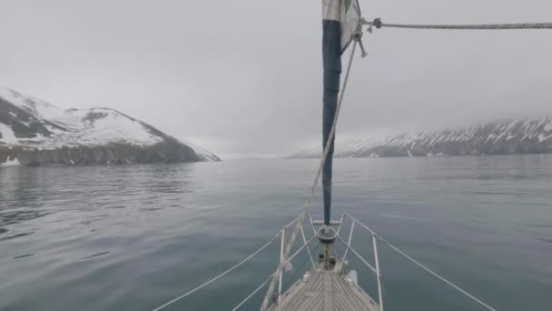 Vista dalla nave di prua che naviga su montagne innevate e paesaggio roccioso in mare — Video Stock