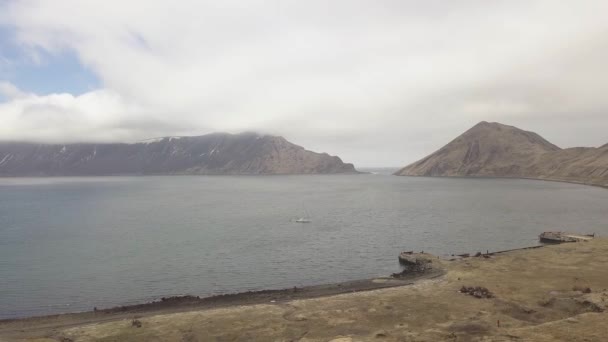 Havadan görünümü Yelkenli tekne deniz kıyısında eski limanda terk edilmiş piers yakınındaki — Stok video