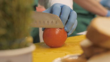 El kesme domates daire dilimleri ve parçalar halinde Restoran için bıçak kullanarak Cook