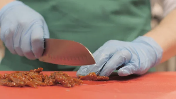Szakács szakács késsel a vágás pörkölt hús étteremben főzés közben közelről — Stock Fotó