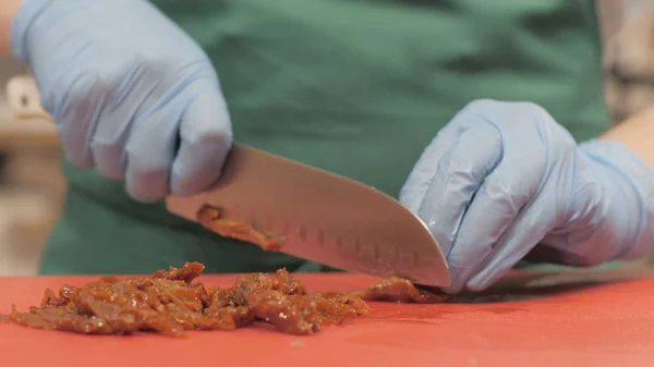 Chef cook using knife for cutting stew meat while cooking in restaurant close up