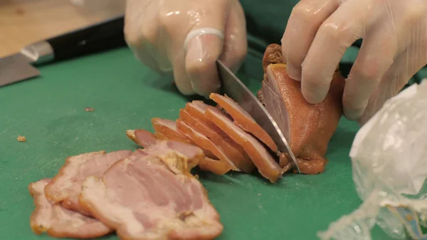 Cocine utilizando un cuchillo para cortar la piel de cerdo ahumada mientras cocina en primer plano —  Fotos de Stock