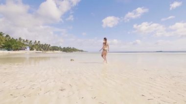 Bikini kum ve poing yaz deniz plaj üzerinde çalışan genç kadın