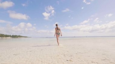 Mutlu kadın deniz sahilde temiz su üzerinde çalışan ve kamera için poz bikini