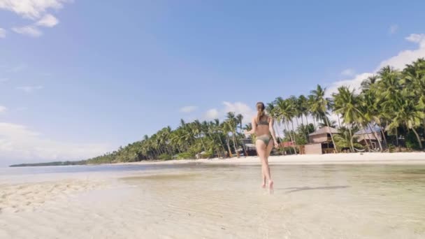Ανέμελη γυναίκα που τρέχει στο νερό της θάλασσας στην παραλία το καλοκαίρι. Κορίτσι στην παραλία παράδεισος — Αρχείο Βίντεο