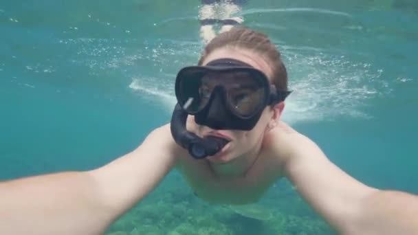 Enfréntate a un joven con máscara de snorkel y snorkel mientras nadas bajo el agua en el mar azul. Selfie hombre de vídeo snorkeler nadando en agua de mar turquesa juntos amiga chica. Esnórquel y buceo . — Vídeo de stock