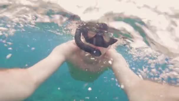 Retrato joven en máscara de snorkel y snorkel nadando bajo el mar y filmando video selfie. Hombre haciendo snorkel en máscara y snorkel bajo agua de mar transparente . — Vídeo de stock