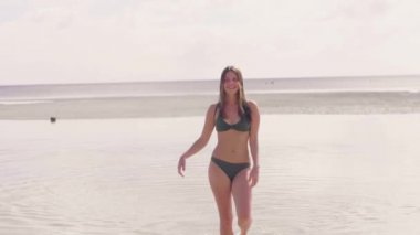 Oynak kadın deniz suyu yaz sahilde dans bikini. Sumnny gün deniz kumsalda dans mayo mutlu bir kadın. Islak saç sallayarak ve okyanus kıyısında kamera poz portre çekici kadın