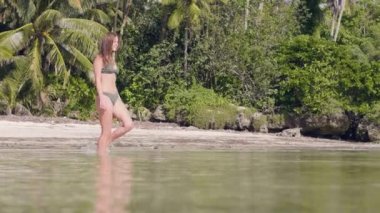 Çekici kadın bikini Cennet plaj üzerinde berrak deniz suya girme. Okyanus su tropik adada yürüyen güzel kadın. Palmiye ağacı manzara sahilde deniz yaz kız.