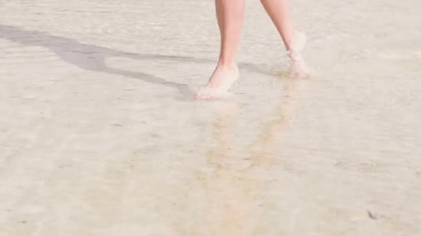 Jambes femelles courant sur l'eau transparente à la plage de la mer au ralenti. Jeune femme pieds nus courant sur l'eau cristalline de l'océan à la plage paradisiaque. Profitez des vacances d'été .