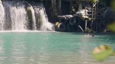Art arda sıralı şelale tropik şelale ve genç kadın taze su sıçramasına. Dağ nehir akan güzel tropik şelale. Tropikal nehir su dökme.