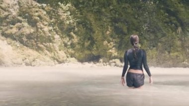 Kadın dağ Gölü ve su akışı tropik şelale akan seyahat. Turist kadın şelale göl yağmur ormanlarında banyo. Kız ormanda uçurumun üzerinden arka plan waterflow.