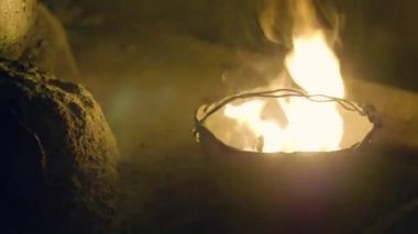 Yanan alev ateş karanlık akşam Melon tencerede. Karanlık gecede kamp sırasında su ısıtıcısı tencereye yanan turist ateşi.