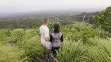 Yeşil dağ tepe üzerinde sarılma ve güzel zevk mutlu çift manzara. Erkek ve kadın yeşil tepe ve yayla arka plan kucaklayan.