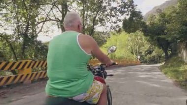 Seyahat eden adam bisiklet üzerinde yaz tatilinde sürüş. Güneş arka planda yolda motosiklet sürme kıdemli adam. Moto seyahat konsepti.