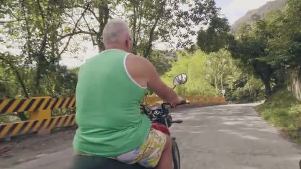 Uomo in viaggio che guida in moto durante le vacanze estive. Uomo anziano guida moto su strada su sfondo sole. Moto concetto di viaggio . — Video Stock