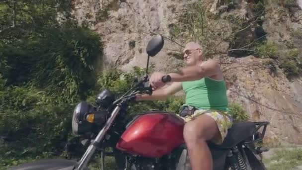 Vahşi adam binicilik bisiklet üzerinde yol dağ manzara iken yaz seyahat. Motosiklet üzerinde sürüş Kıdemli adam Moped Sürücüsü yakın. — Stok video