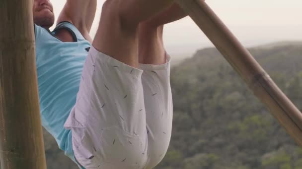 Homme sportif faisant de l'exercice abdominal tout en abs formation sur barre transversale en bois en plein air. Athlète homme d'entraînement des muscles de l'estomac sur la barre horizontale. Abs séance d'entraînement . — Video