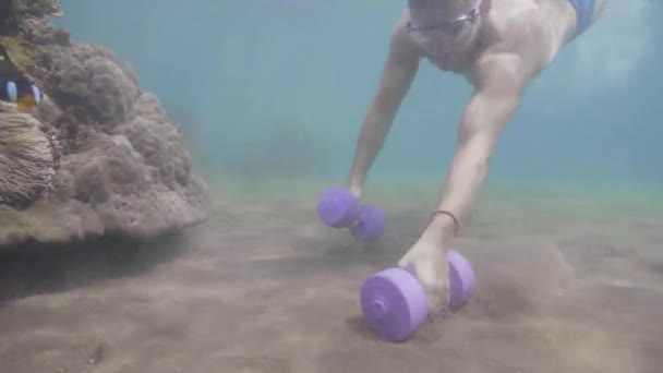 Deportista en máscara está haciendo ejercicios de bíceps mano con mancuernas bajo el agua . — Vídeo de stock