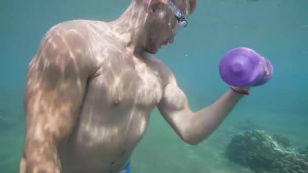 L'homme athlétique s'entraîne avec des haltères sous l'eau, des exercices manuels. Fitness sous-marin . — Video