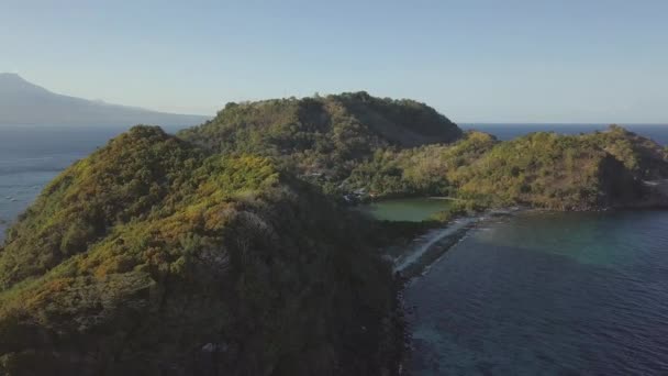 Antecedentes con isla tropical en el océano con pueblo y lago entre las montañas, vista aérea . — Vídeo de stock