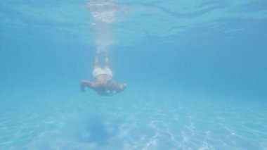 Waterline görünümü tatil otelde sualtı yüzen havuz yüzme olgun adam. Tropik otelde yaz tatili sırasında sualtı yüzme havuzu yüzen yetişkin adam yüzücü.
