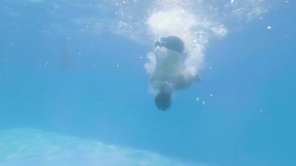 Unterwasserblick Mann Schwimmer Tauchen in blauem Wasser Schwimmbad. Junger Mann springt in schwimmendes Becken und schwimmt in transparentem Wasser . — Stockvideo