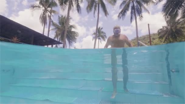 Hombre maduro entrando en la piscina de agua por escaleras en hotel resort vista submarina. Hombre adulto nadando en piscina al aire libre en hotel turístico vista de la línea de flotación . — Vídeos de Stock