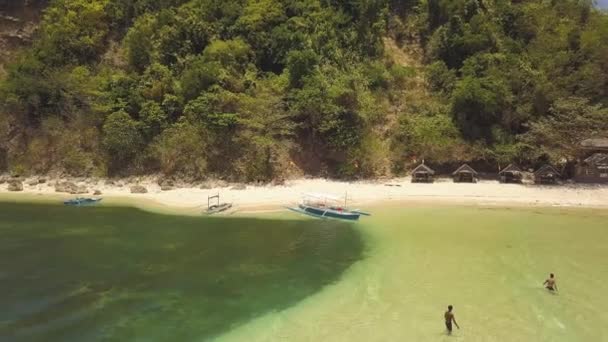 漁師は漁村と緑の丘の海岸に背景駐車場ボートで海に入浴.緑の海とボートと海岸のバンガローの航空写真の人々. — ストック動画