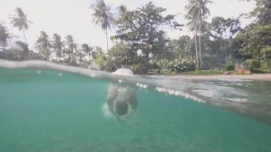 Adam palmiye ile kum plajda okyanusta dalış tropik yaptığı tatil sahiptir.