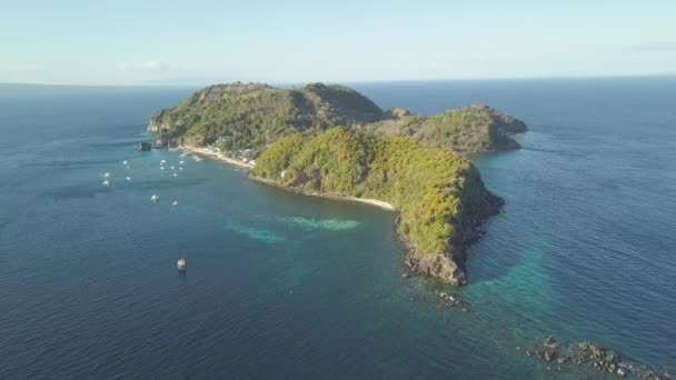 Tropický ostrov pokrýváš tropický les na modré mořské vzdušné krajině. Úchvatný pohled na lodě a lodě plující v modrém moři a zeleném ostrově APO, Filipíny — Stock video