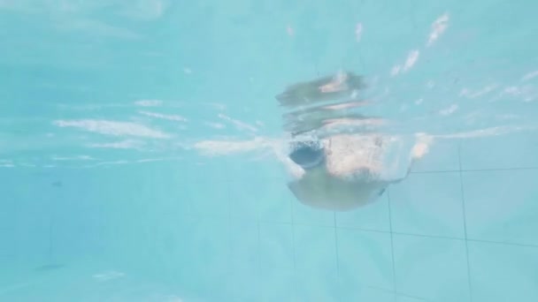 Hombre alegre cayendo en la piscina de agua de la piscina en el complejo de verano. Hombre feliz divirtiéndose vacaciones de verano en la piscina. Vista submarina nadador en el agua . — Vídeos de Stock