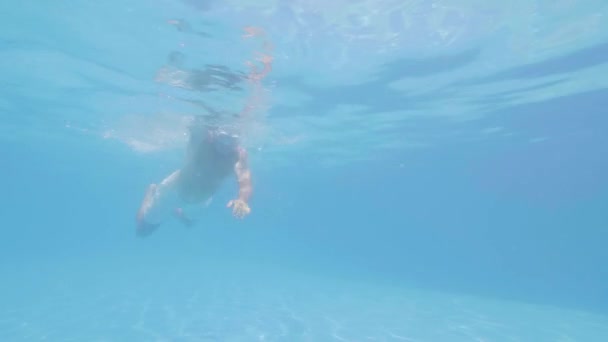 Idoso de óculos está nadando estilo livre na piscina . — Vídeo de Stock