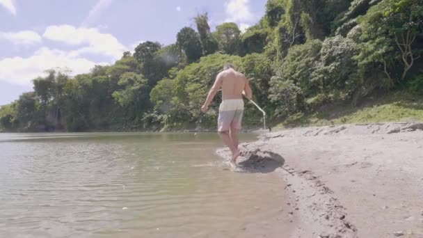 Hombre joven está encontrando lugar para la pesca en la isla tropical . — Vídeos de Stock