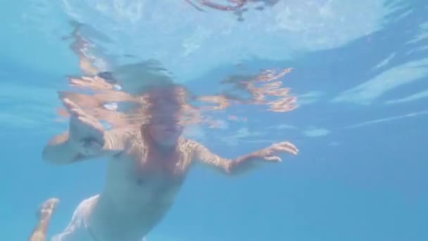 Retied hombre está nadando en la piscina al aire libre en el hotel en la isla tropical en sus vacaciones . — Vídeos de Stock