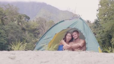 Çadırdaki çift yağmur ormanlarında dinleniyor ve sarılıyor.