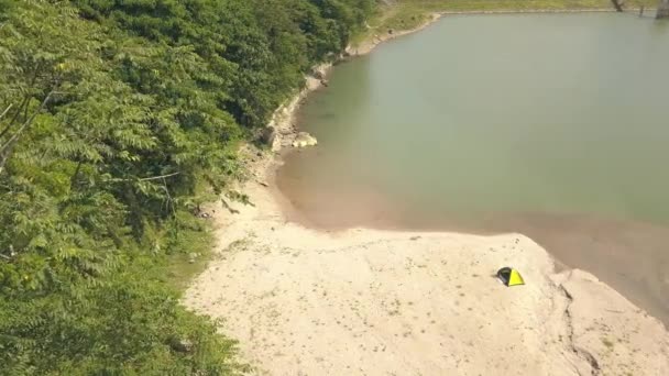 Vista aérea de la familia descansando en la playa de arena en el lago con una tienda de campaña . — Vídeo de stock