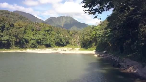 Volare sopra il lago e la foresta pluviale con le montagne nella soleggiata giornata estiva . — Video Stock