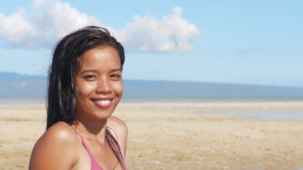 Portrait of attractive asian girl on ocean beach looking at camera and smiling. — Stock Video