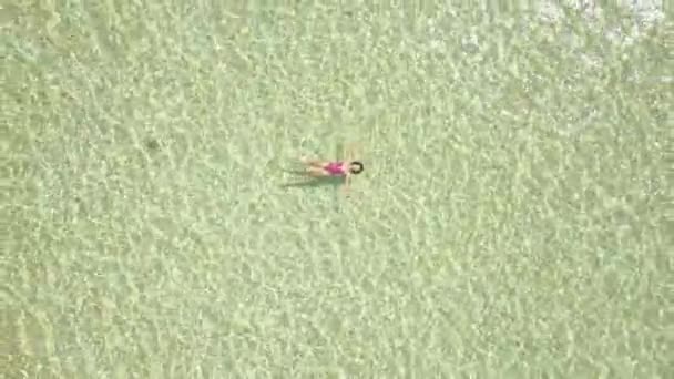 Chica asiática relajarse tendido en la superficie del agua en el océano con los ojos cerrados, vista aérea . — Vídeos de Stock