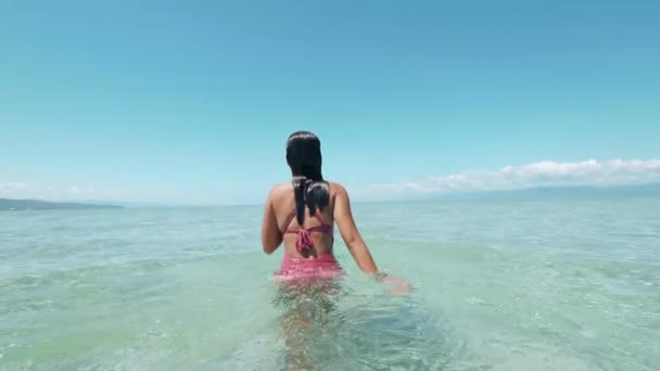 Η Μπρουνέτ ασιάτισσα περπατάει στον καθαρό ωκεανό σε καλοκαιρινές διακοπές. Φιλιππίνες. — Αρχείο Βίντεο