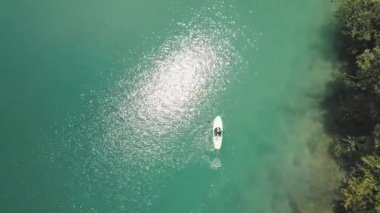 Havadan görünüm: Mavi lagün içinde paddleboarding bir kadının izleme görüntüleri.