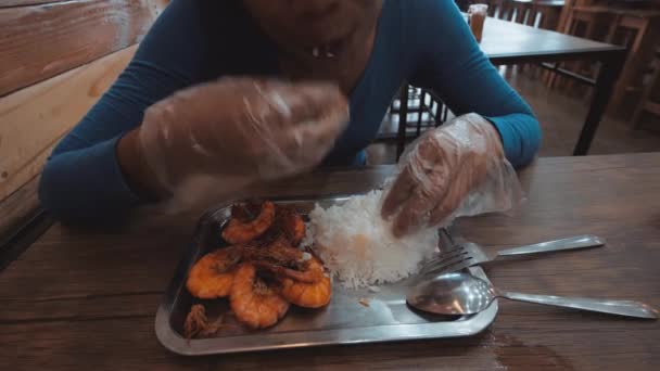 Masada karides ve pirinç yiyen bir kadının kısmi görünümü. — Stok video