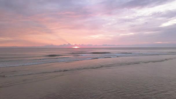 Aerial footage at early morning of vibrant orange sunrise in a surfing place. — Stock Video