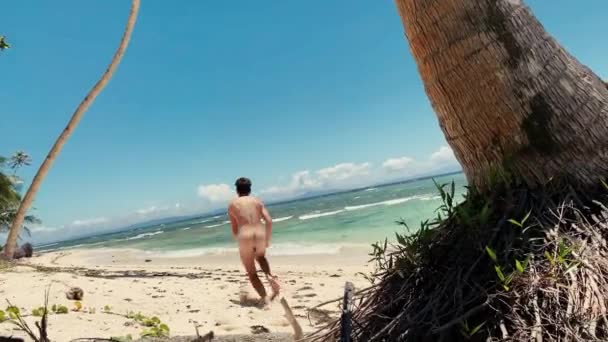 Divertente giovane uomo che corre nudo in una spiaggia deserta tranquilla nelle Filippine . — Video Stock